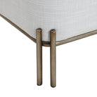Close-up of the painted brass iron leg detail on the white Aurelie Linen Accent Stool.