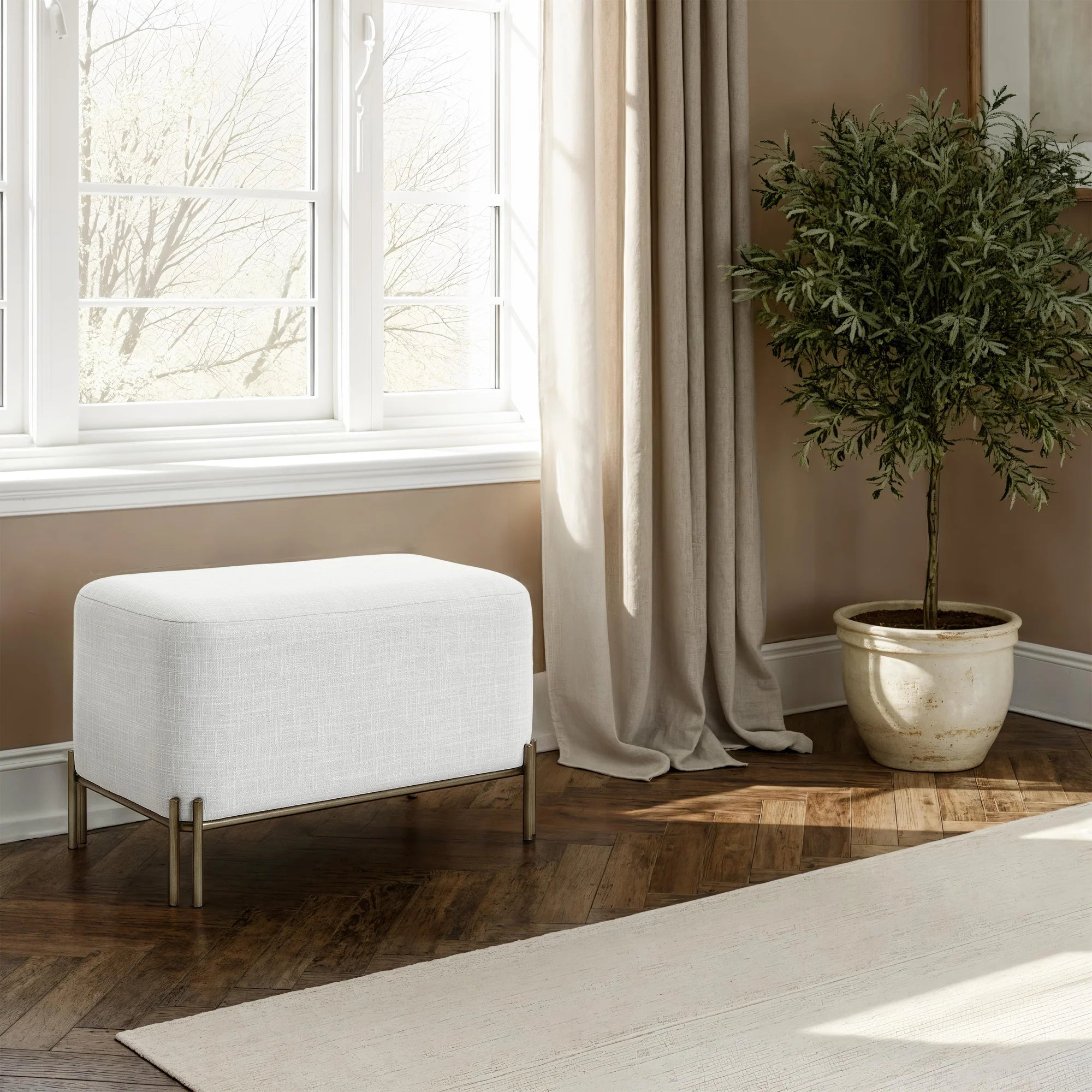 Aurelie Linen Accent Stool in white styled beside a window in a warm contemporary bedroom.