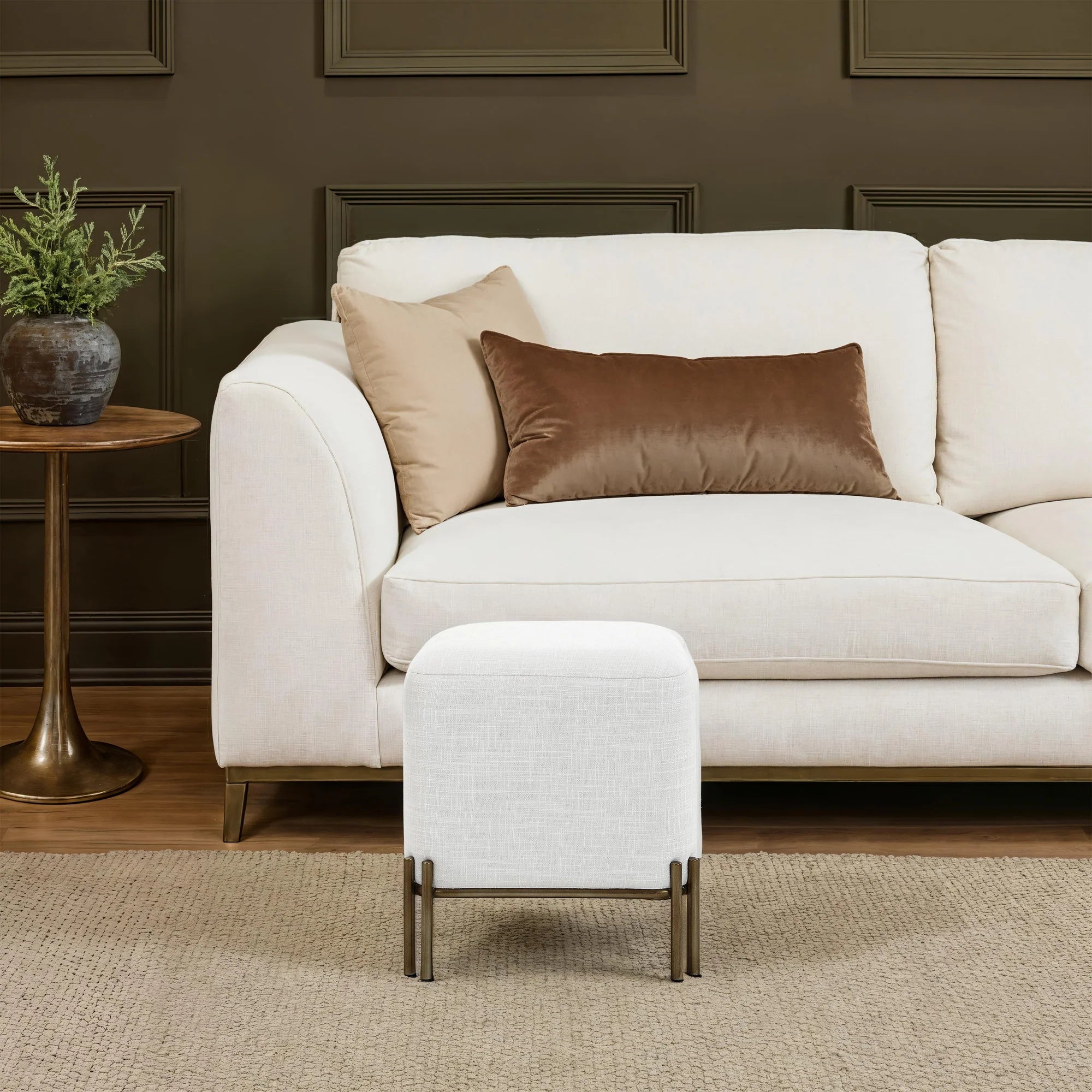 Aurelie Square Linen Accent Stool in white styled in front of a sofa in a warm contemporary living room.