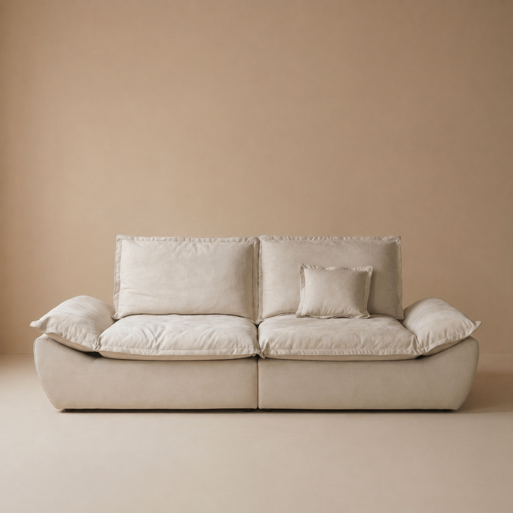 Front studio shot of the sailing-shaped modular loveseat in cream showcasing the flared base design.