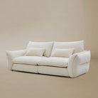 Bella Boucle Sofa with matching throw pillows, set against a minimalist beige studio background.