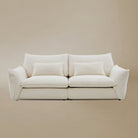 Bella Boucle Sofa upholstered in cream boucle fabric, featuring oversized square back cushions, matching throw pillows, and flared armrests, set against a solid beige studio background.