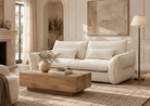 Bella Boucle sofa in a warm-toned living room featuring a wooden coffee table, a floor lamp, and a large abstract painting on the wall.