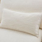 A rectangular cream bouclé lumbar pillow resting on Bella Boucle Sofa.