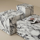 Angled view of a geometric marble-patterned plinth side table set showing block construction and varying heights.