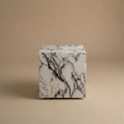 Marble-patterned cube on a beige background