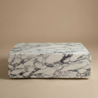 White and grey veined sintered stone plinth coffee table with a monolithic block design.