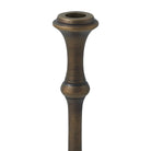 Close-up of a Caldria candle holder showing the taper candle opening and antique brass-finished upper stem.