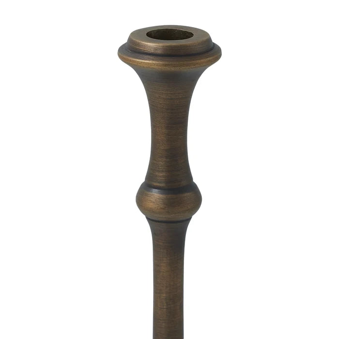 Close-up of a Caldria candle holder showing the taper candle opening and antique brass-finished upper stem.