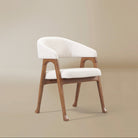 Angled front view of the Calira linen dining chair showing its curved upholstered arms and arched openings in the ash wood veneer frame