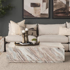 Calista Marble Plinth Coffee Table styled in a contemporary living room with neutral upholstery and warm accents.