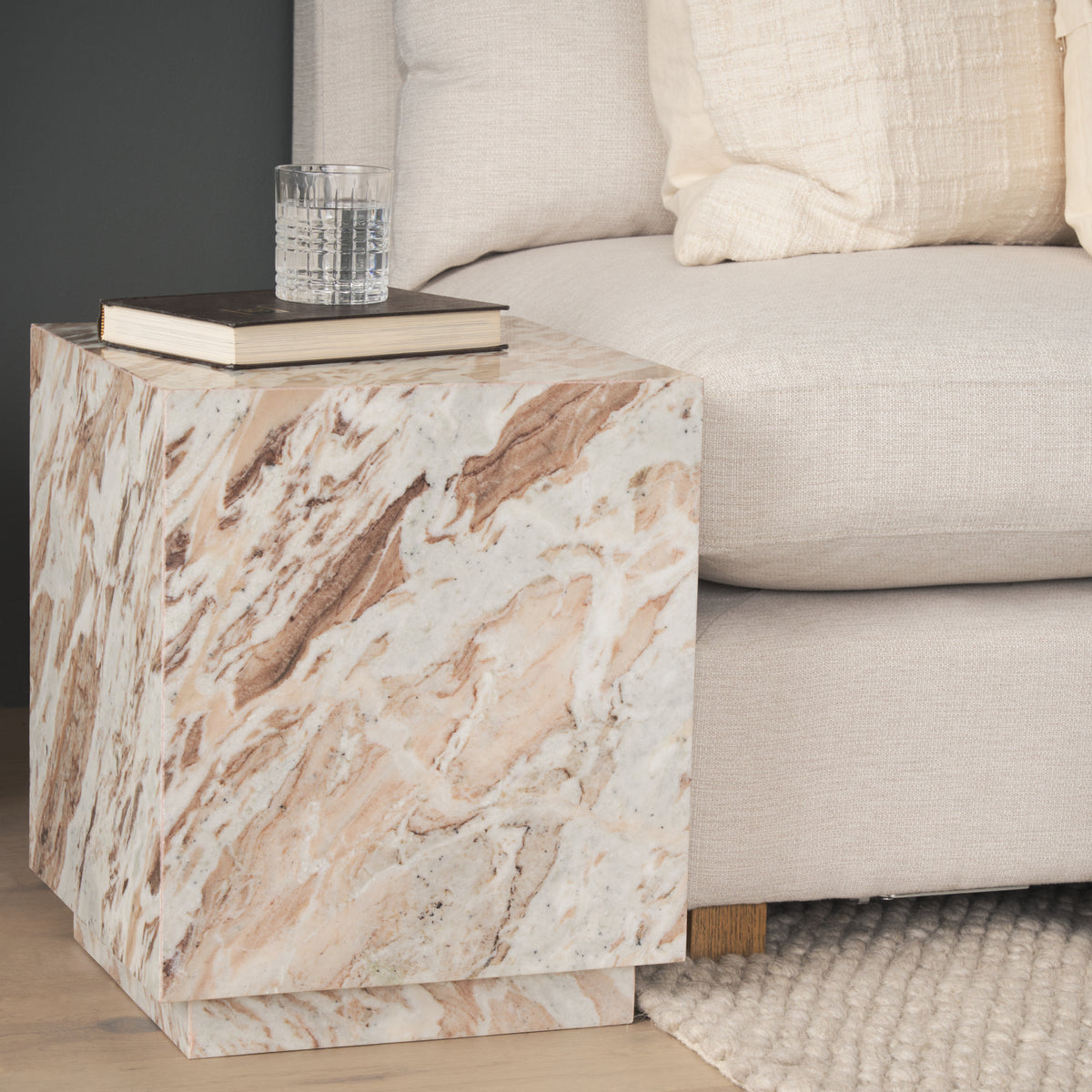 Calista Marble Plinth Side Table styled beside a neutral sofa in a contemporary living room.