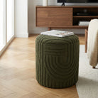 Green textured ottoman with a magazine on top in a living room setting.