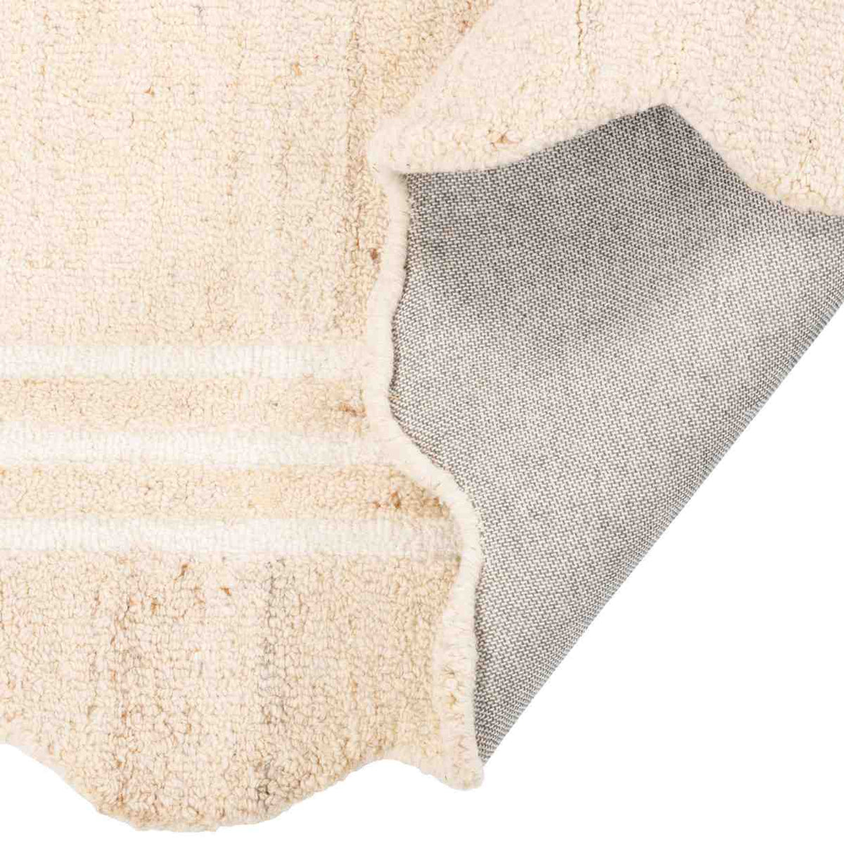 Camille Hand-Tufted Wool Rug folded back to show the cream wool surface, bound edge, and woven cotton backing.