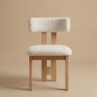 Front view of the modern dining chair featuring a natural light ash wood frame with a central back leg and a textured white bouclé seat featuring the Casper...