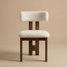 Front view of the modern dining chair featuring a dark ash wood frame with a unique central back leg and a textured white bouclé seat featuring the Casper...
