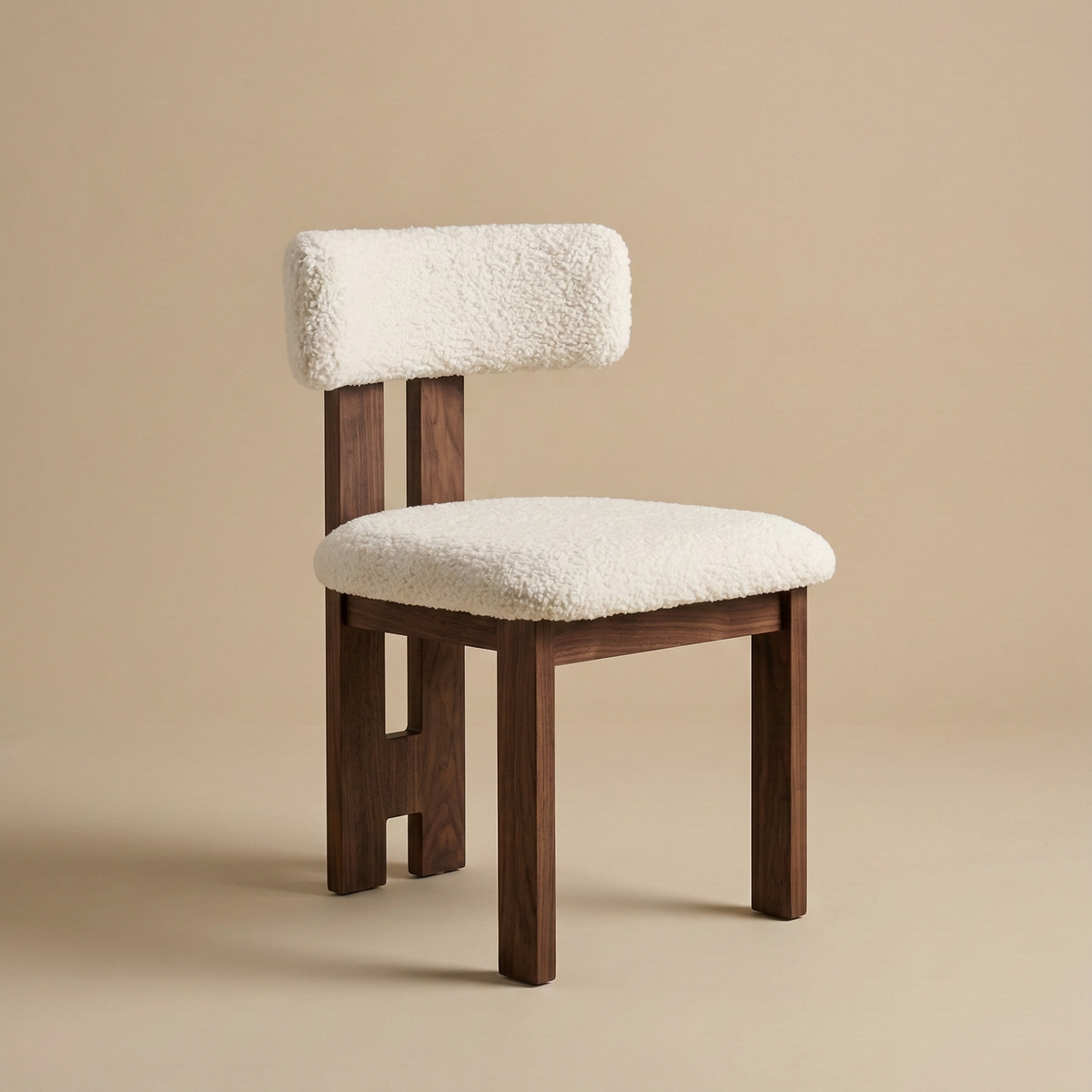 Angled view of the bouclé dining chair showing its curved backrest, plush white textured upholstery, and dark ash wood legs featuring the Casper Bouclé...