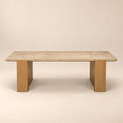 Front studio view of the Cavelle Travertine & Oak Coffee Table with a rectangular beige travertine top and light brown oak blade legs on a warm beige background.