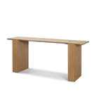 Angled studio view of the Cavelle Travertine & Oak Console Table showing the long rectangular travertine top and solid oak blade legs.