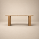 Front studio view of the Cavelle Travertine & Oak Console Table with a beige travertine top and light brown oak blade legs on a warm beige background.
