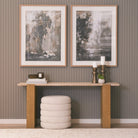 Cavelle Travertine & Oak Console Table styled against a paneled wall with framed artwork and neutral decor.