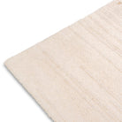 A close-up of the Claire Hand-tufte rug or fabric corner, showing its soft woven surface and fine edges against a plain white background