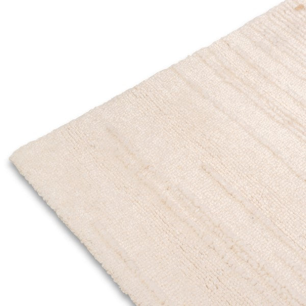 A close-up of the Claire Hand-tufte rug or fabric corner, showing its soft woven surface and fine edges against a plain white background