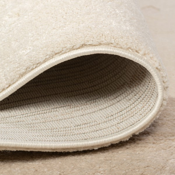 Folded edge detail of the Dreamy Arc Kids Rug showing its bound edge and woven backing.