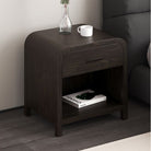 Dark walnut Eamon Nightstand styled beside a dark upholstered bed
