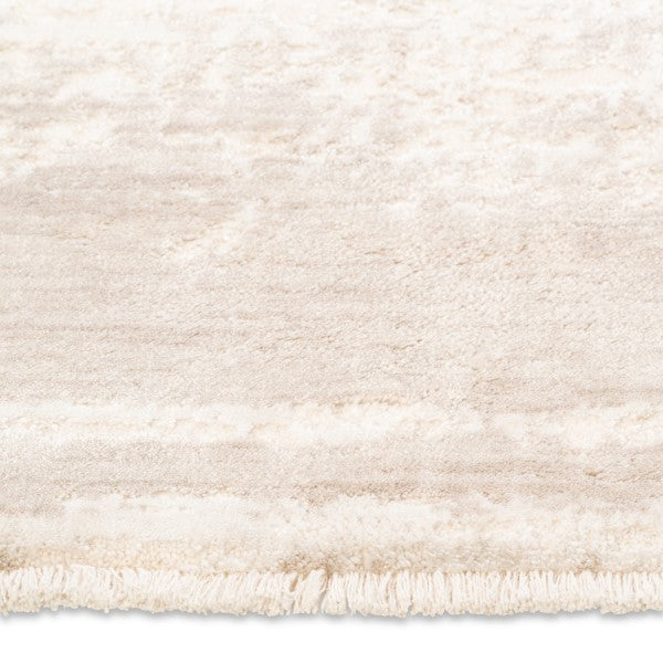 Close-up of the short delicate fringe and soft distressed pile on the cream and beige Elara soft-touch rug.
