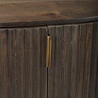 Macro detail of the textured fluted doors and vertical brass hardware on the dark wood Eleanor cabinet.
