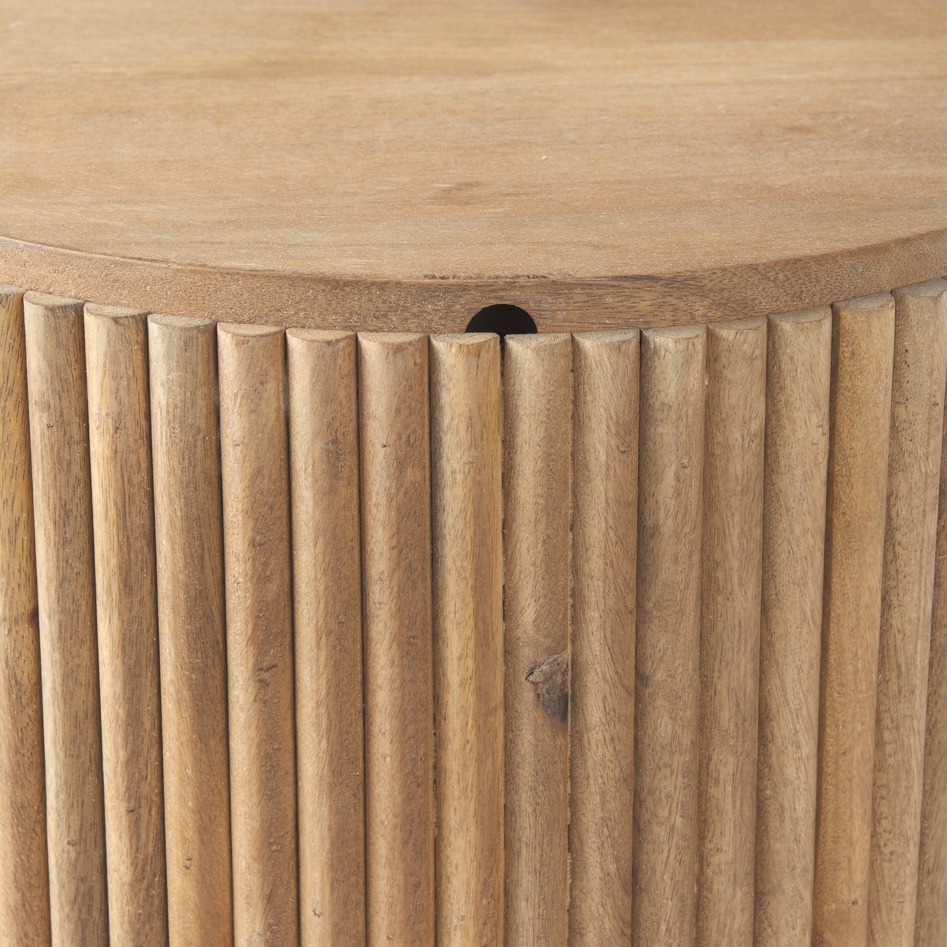 Close-up of the vertical fluted wood detailing and the smooth edge of the lid on the Eleanor mango wood side table.