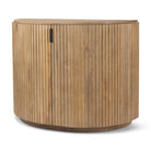 Angled view of the closed Eleanor light mango wood accent cabinet featuring fluted details and black pulls.