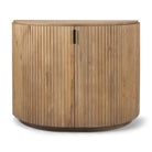 Full front view of the Eleanor natural light mango wood accent cabinet featuring two fluted doors and a curved shape.