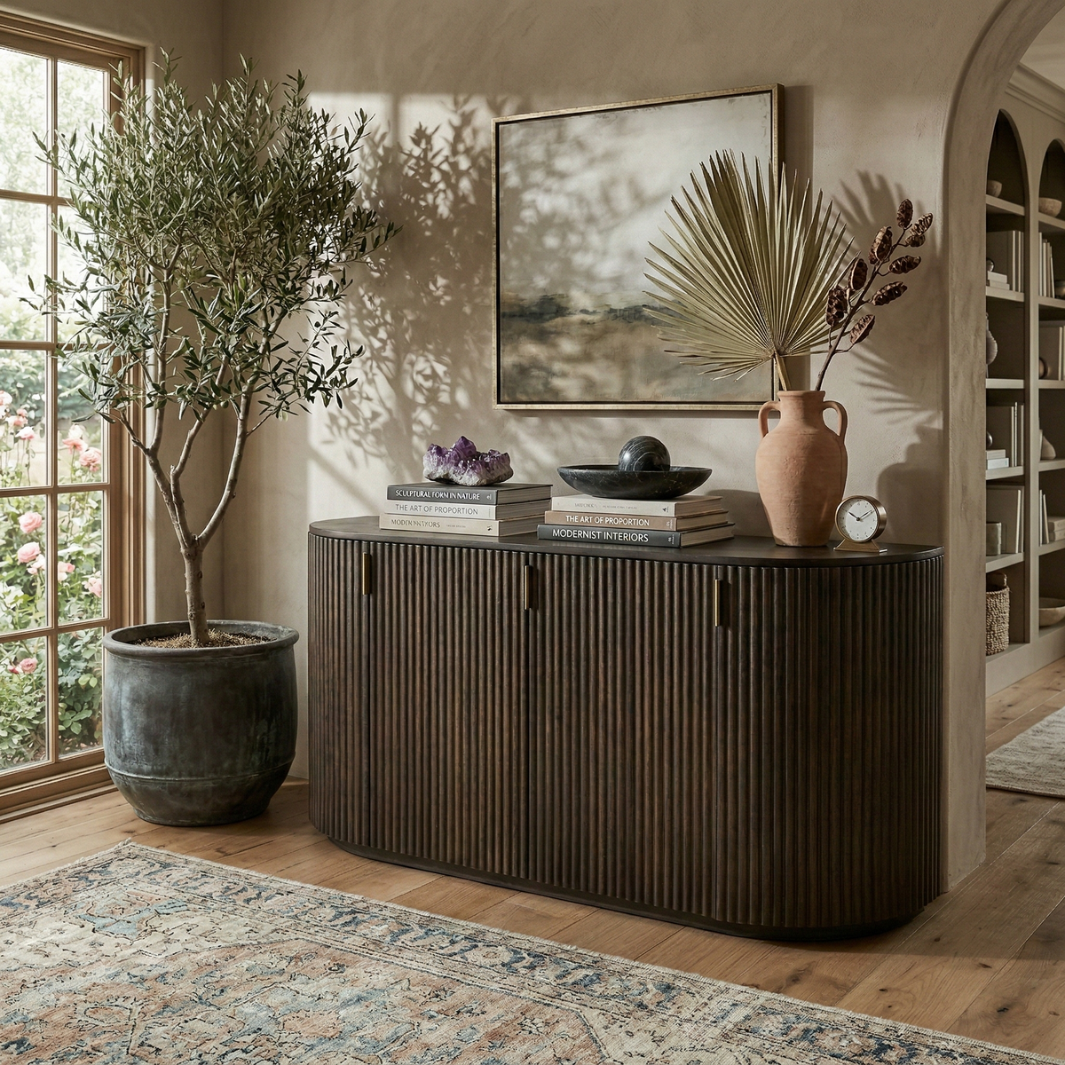 Eleanor dark mango wood sideboard styled in a warm, neutral living room with an olive tree and earthy decor