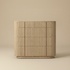 Elias wide oak dresser featuring continuous vertical fluting, rounded corners, and spacious storage drawers for a modern organic bedroom.