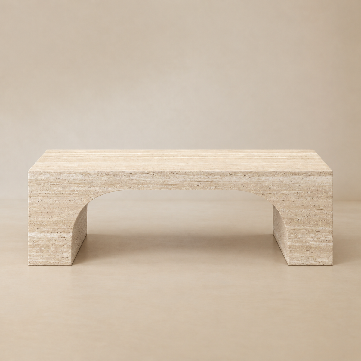 Front view of the Elio Travertine-Look Coffee Table with its sculptural arched base on a beige studio background