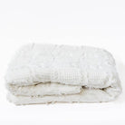 Stack of white textured towels on a white background