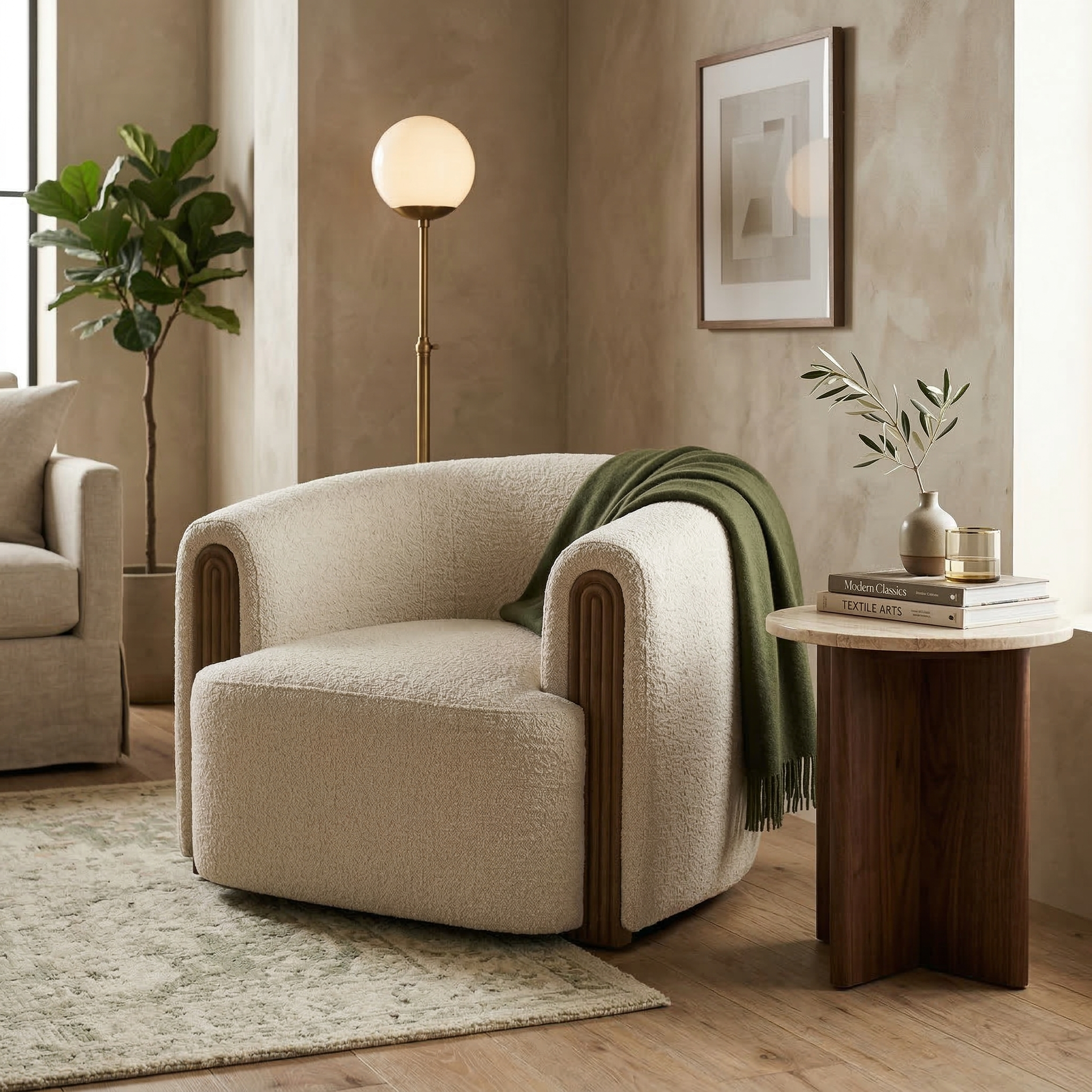 The cream Elodie barrel chair styled in a contemporary living room with a green throw, walnut side table, and textured rug.