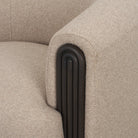 Macro close-up of the Elodie chair’s armrest showcasing the deep vertical fluting in a dark black wood finish.