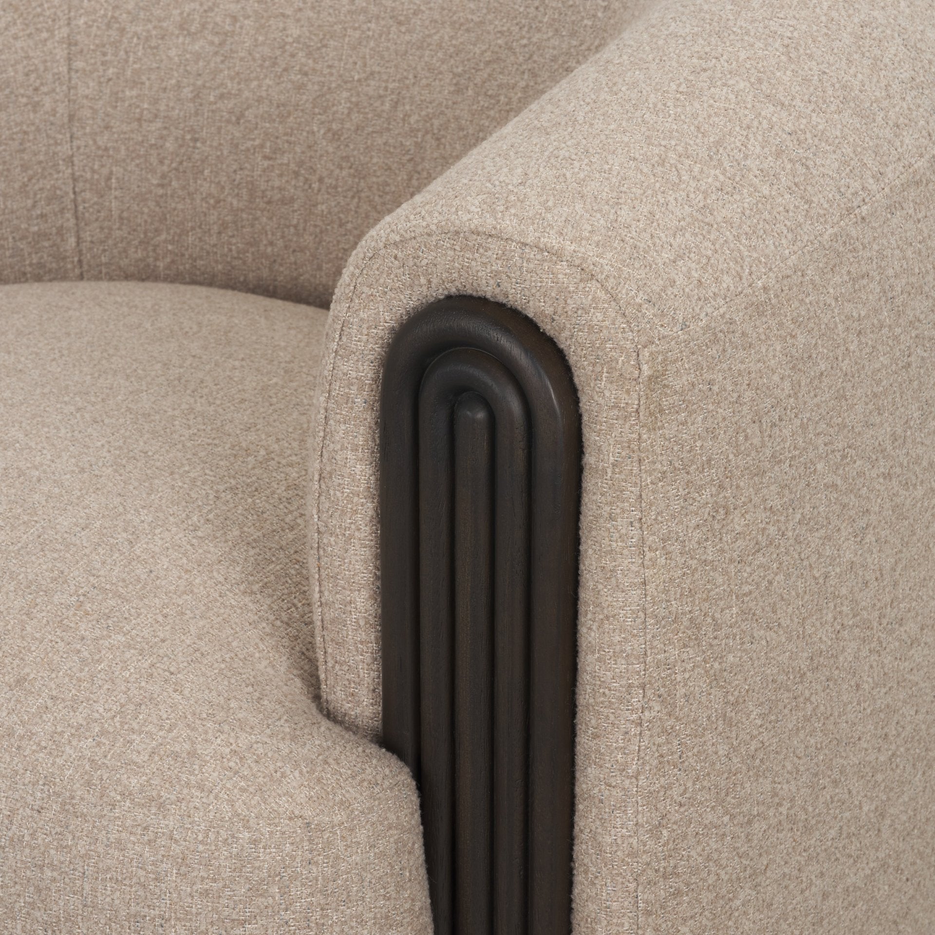 Macro close-up of the Elodie chair’s armrest showcasing the deep vertical fluting in a dark black wood finish.