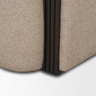 Detail shot of the Elodie chair showing the elegant transition where the black fluted wood meets the beige textured frame.