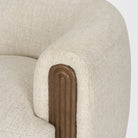 Macro close-up of the Elodie chair's armrest highlighting the deep vertical fluting and warm natural wood grain.