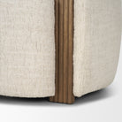 Detail shot showing the elegant integration of the fluted wood panel into the cream bouclé frame of the Elodie chair.