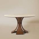 Elowen Round Dining Table with white top and sculpted walnut base against neutral beige background