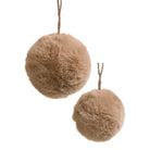 Two fluffy faux-fur pom-pom ornaments in a warm taupe-brown color, each suspended by a thin jute string against a plain white background.