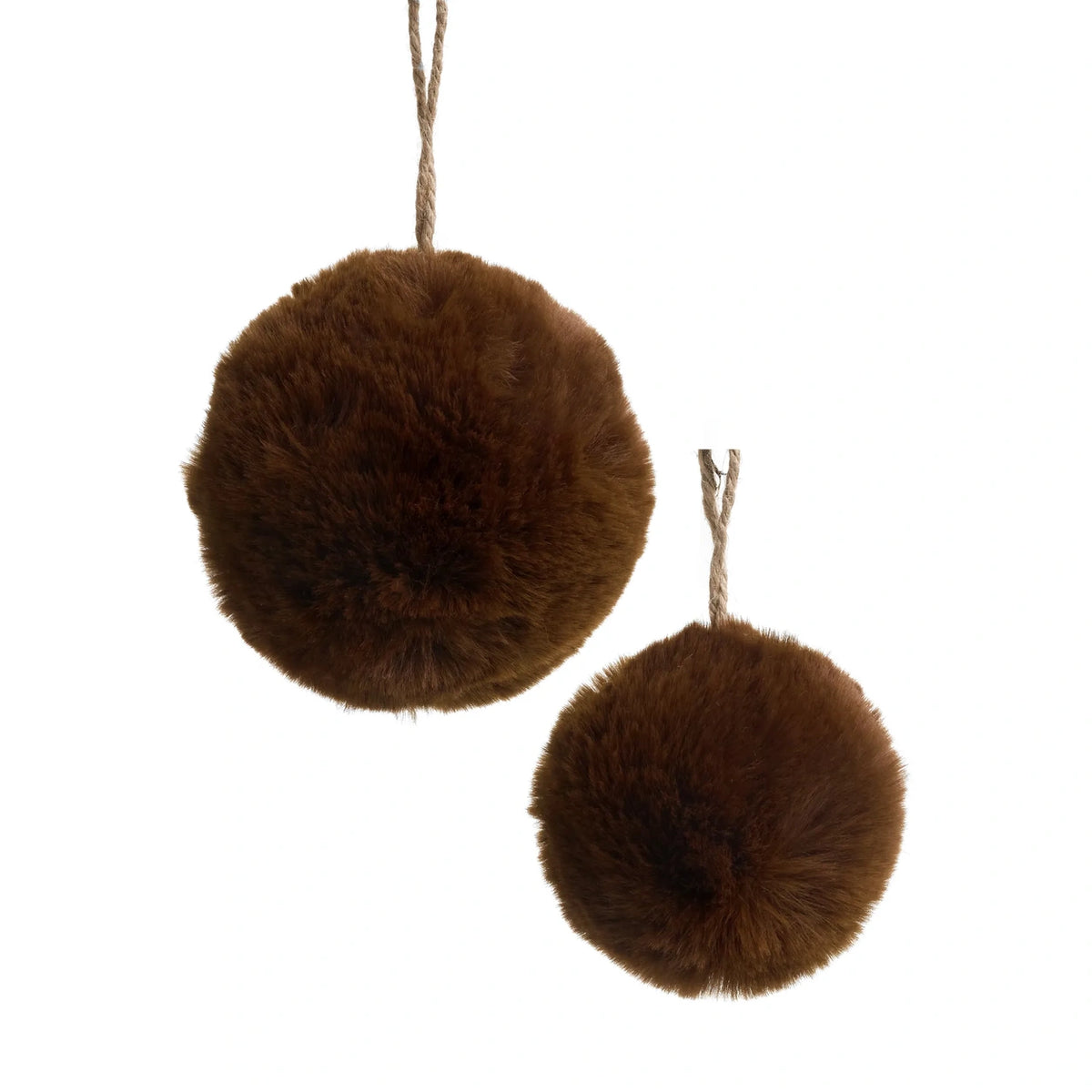 Two brown faux fur pom-pom ornaments hanging from natural jute ropes against a solid white background.