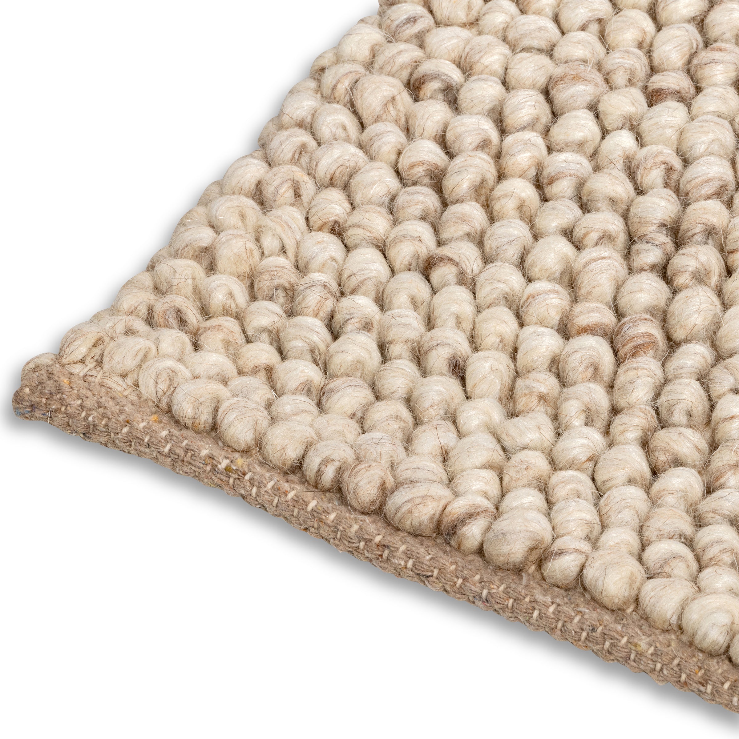 Detailed view of the woven edge and chunky round nodules on the beige Felix handmade textured rug.