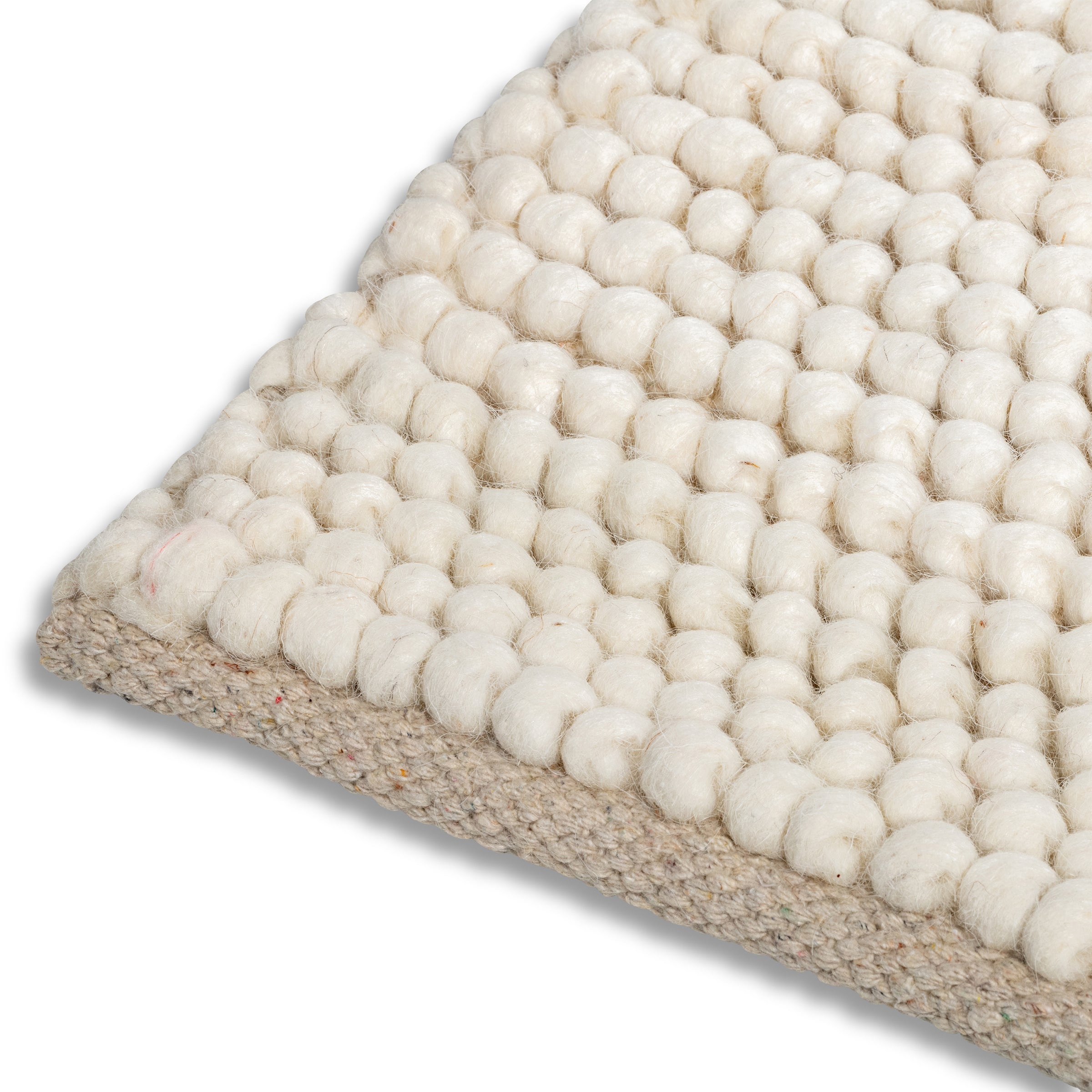Detailed view of the bound edge and chunky round knots on the cream ivory Felix handmade textured rug.