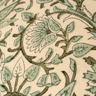 Close-up of a floral pattern with green leaves and brown stems on a beige background